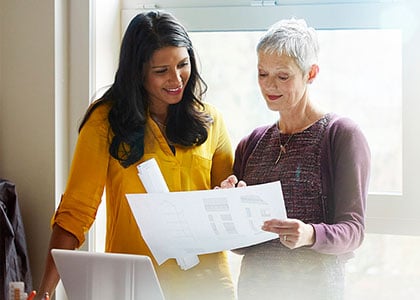 Two colleagues go over paperwork together