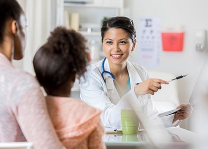 Doctor talking to child and parent