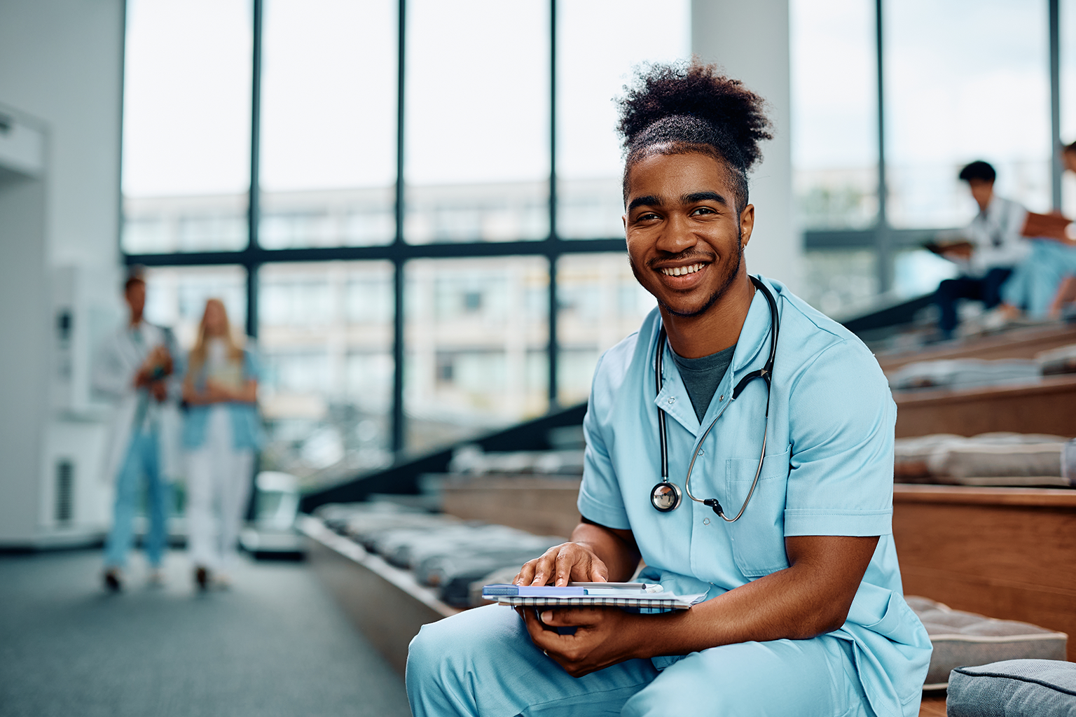 Healthcare student sits in lecture room smiling